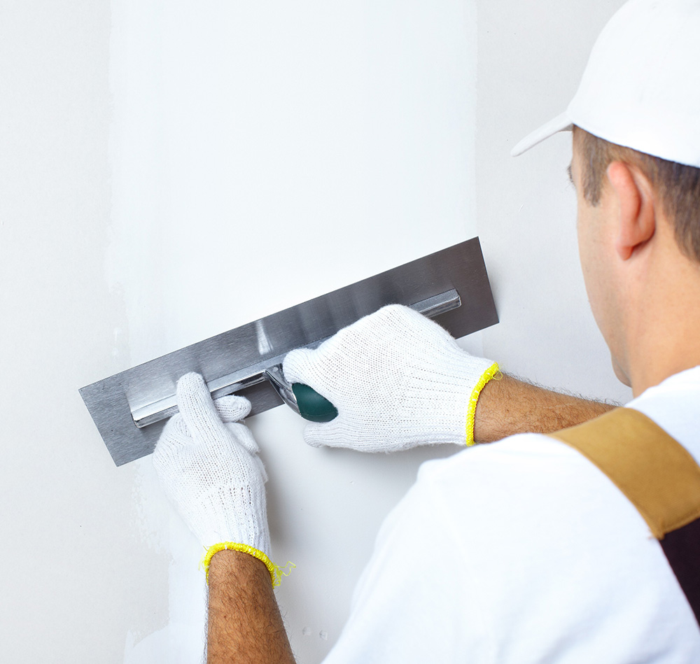 homme aplication enduit mur